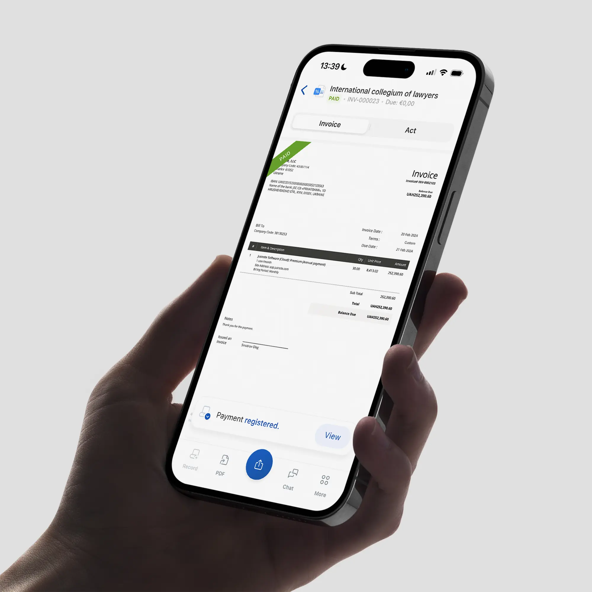A hand holding iPhone 15 Pro displaying the Jusnote invoicing module designed by Smotrow Design with a clear 'Payment registered' notification at the bottom.