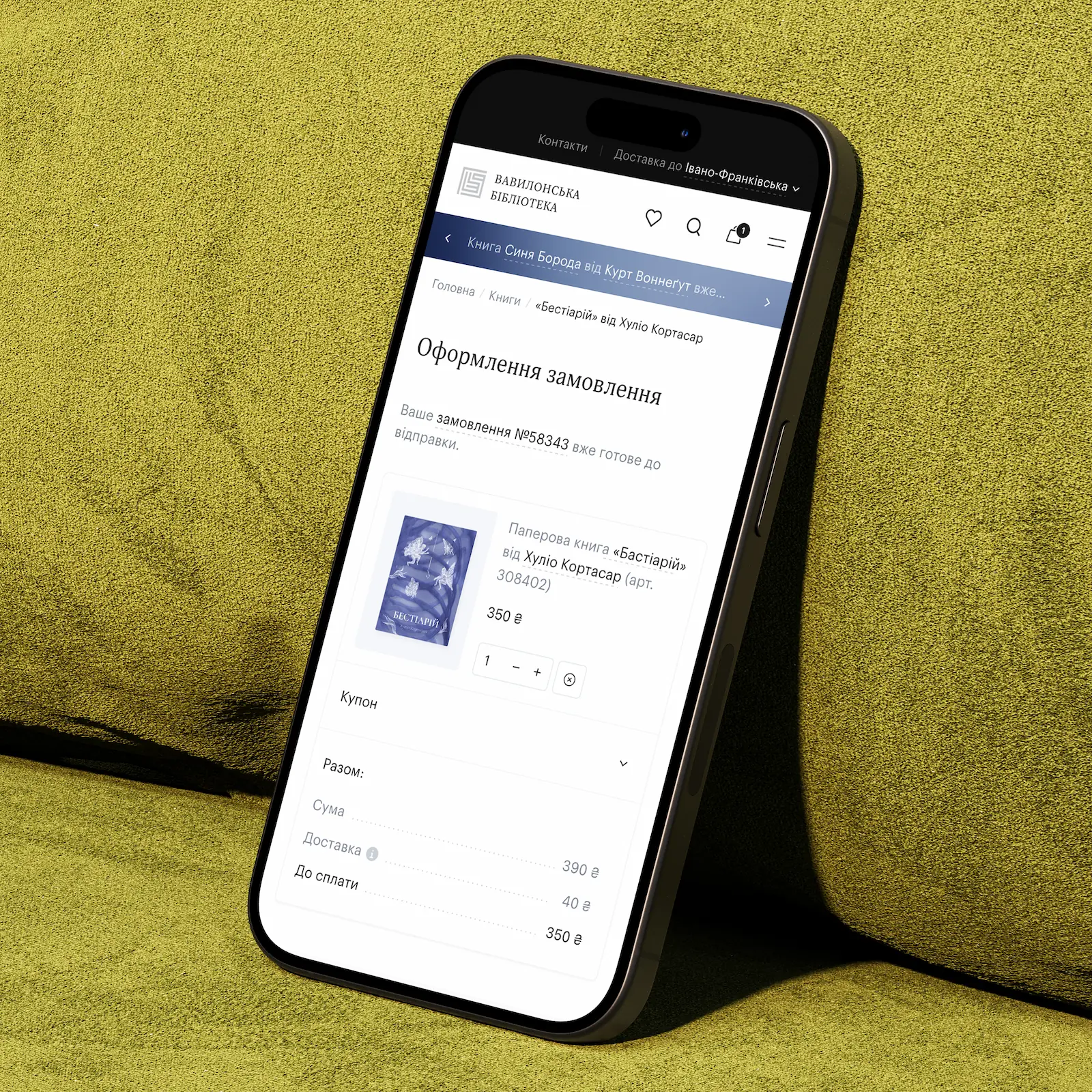iPhone 15 Pro of a green sofa with the opened Babylon Library online bookstore platform designed and technically implemented by Smotrow Design